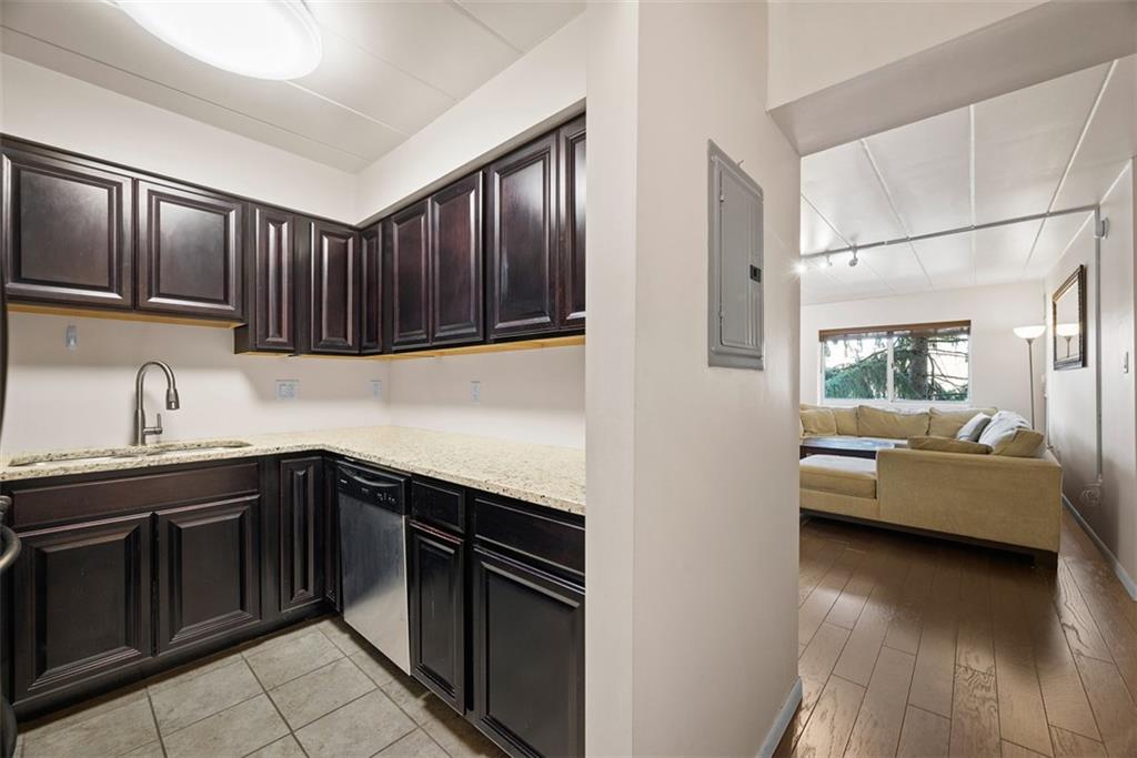 5 Bayard Road, Unit 121 Pittsburgh, PA 15213 - Photo 8 of 24 The kitchen, with its dark cabinets, exudes a sophisticated and inviting atmosphere perfect for cooking and entertaining.