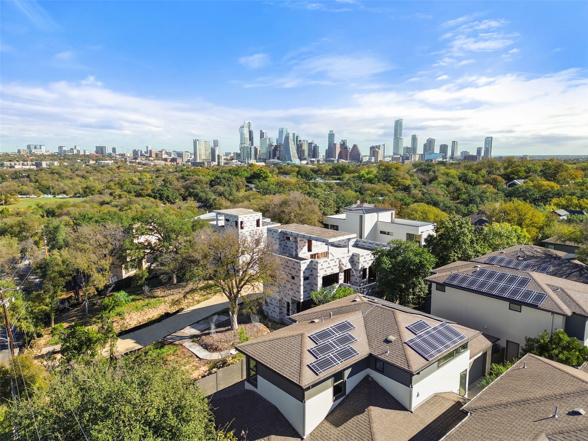 Sweeping city-skyline views set above a lush expanse of trees.