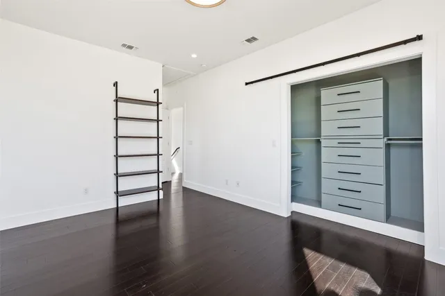 a view of walk in closet with empty racks