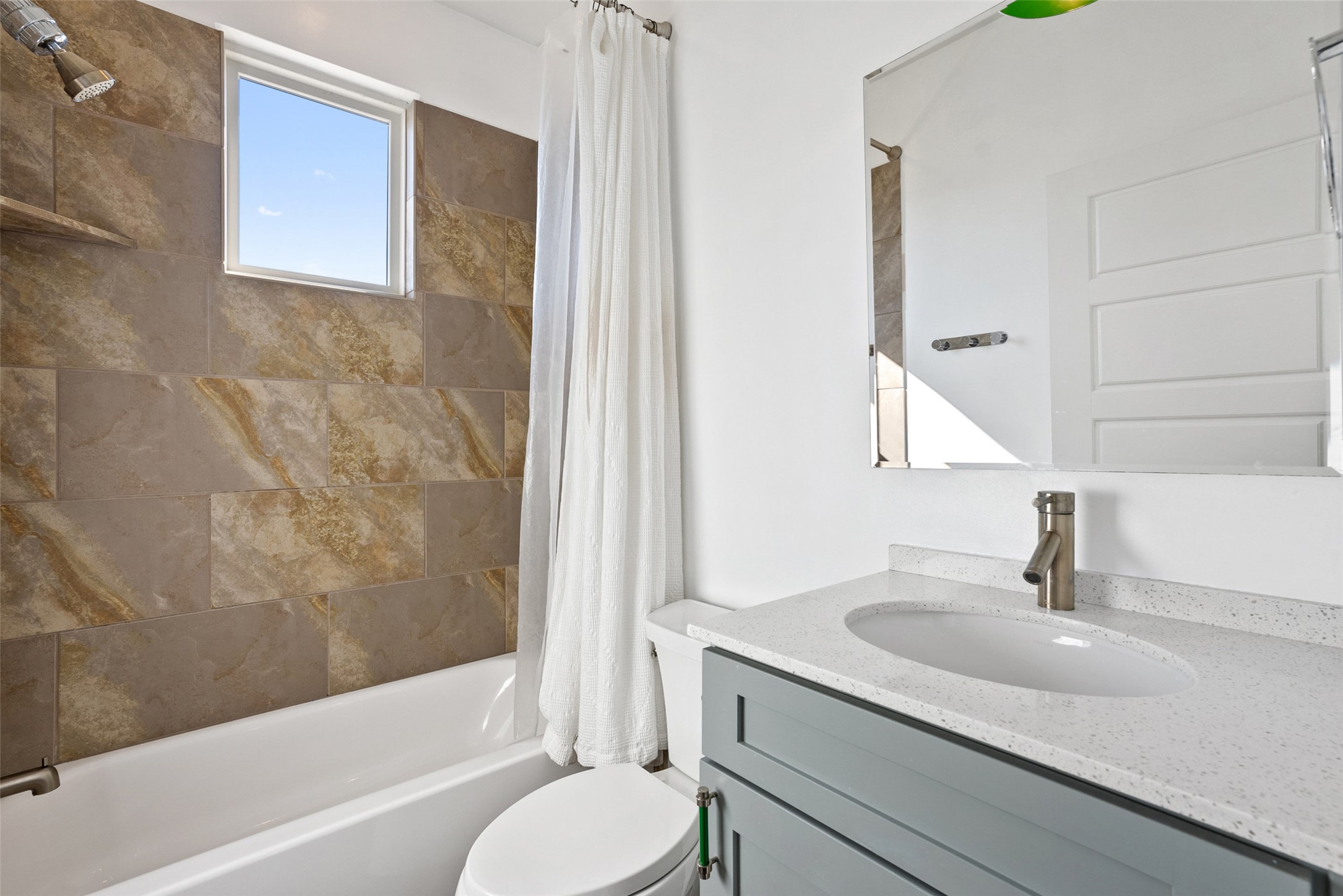 1303 Azie Morton Road, Unit 6 Austin, TX 78704 - Photo 35 of 40 This photo features a bright secondary bathroom offering a full tub/shower combination with a focus on warm, natural materials.