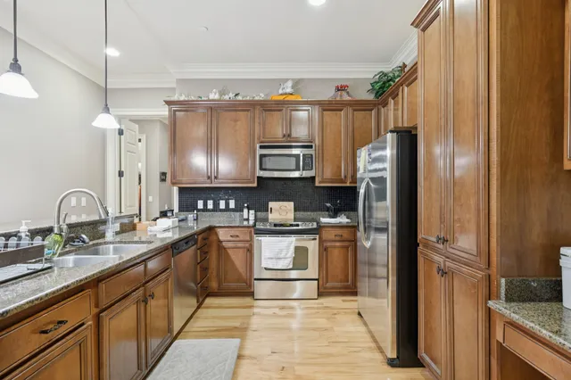 a kitchen with stainless steel appliances granite countertop a refrigerator and a sink