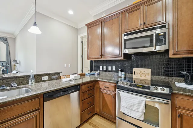 a kitchen with stainless steel appliances granite countertop a sink stove and microwave