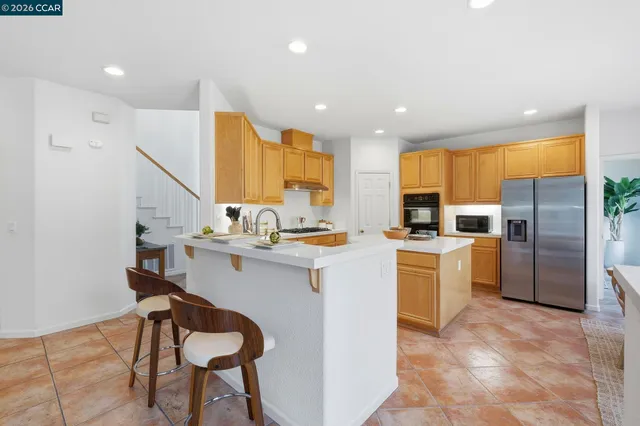 a kitchen with stainless steel appliances granite countertop a refrigerator and a stove top oven
