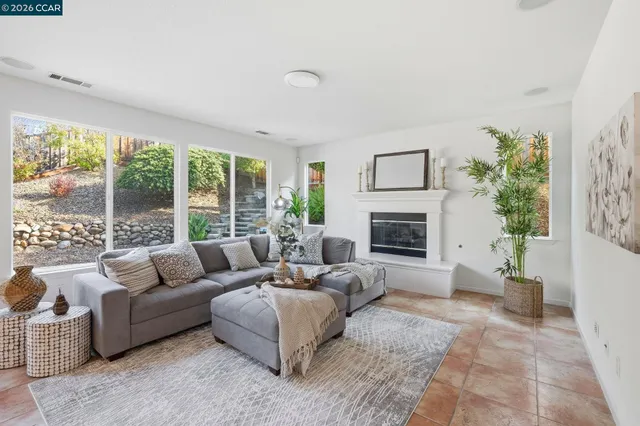 a living room with furniture fireplace and a large window