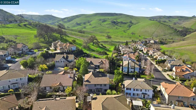 an aerial view of a city with lots of residential buildings ocean and mountain view in back