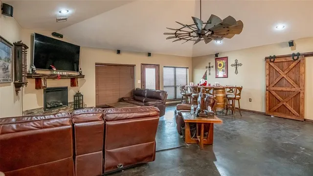 a kitchen with stainless steel appliances kitchen island granite countertop a table chairs and a refrigerator