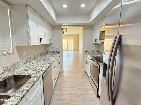 a kitchen with stainless steel appliances granite countertop a sink stove and refrigerator