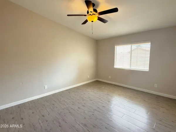 an empty room with a window and a fan