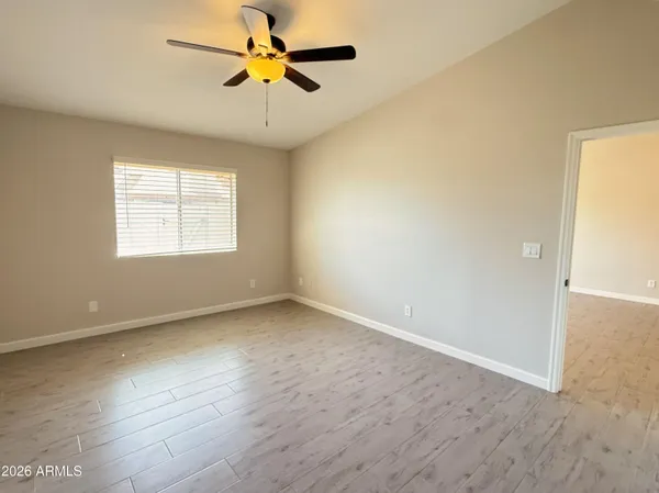 an empty room with windows and fan