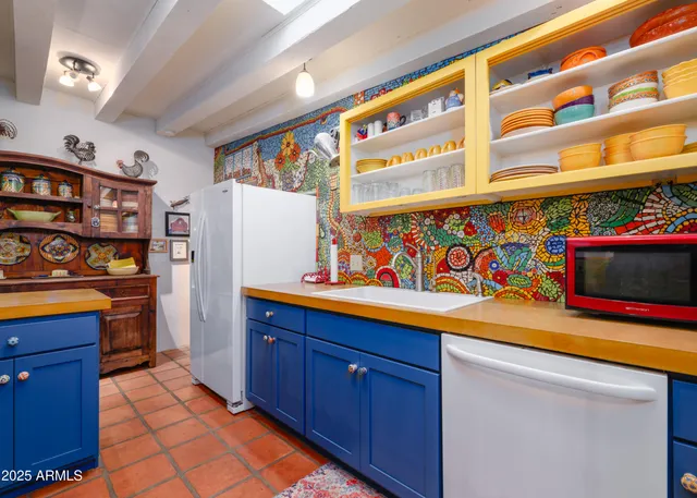 a kitchen with stainless steel appliances kitchen island granite countertop a table chairs and a refrigerator