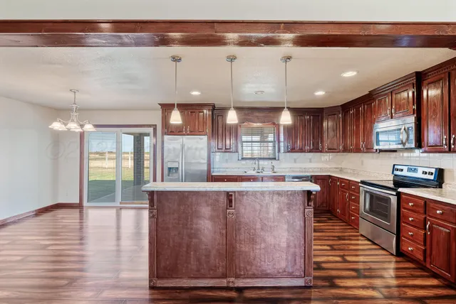 a kitchen with stainless steel appliances granite countertop a stove and a wooden floors