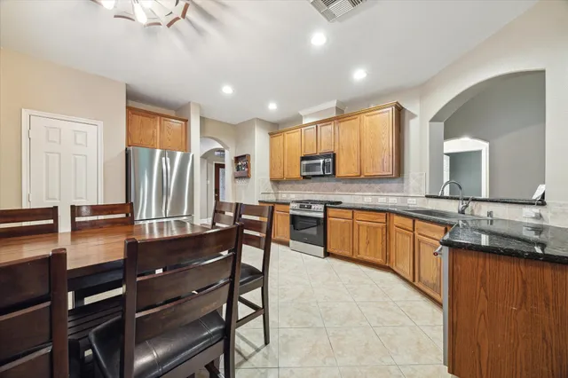 a large kitchen with granite countertop a sink counter space cabinets and stainless steel appliances