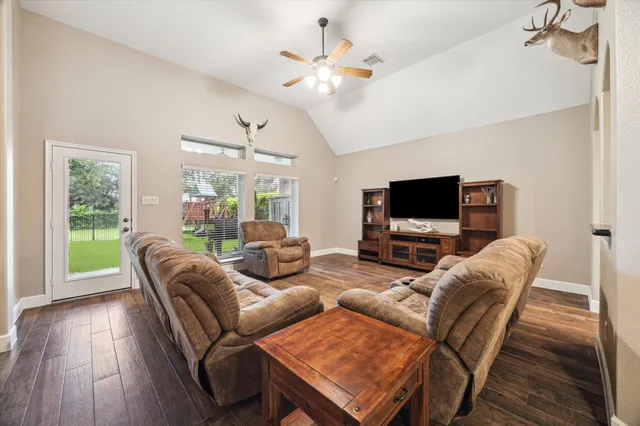 a living room with furniture a flat screen tv and a large window