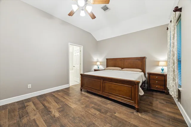 a spacious bedroom with a bed and a chandelier