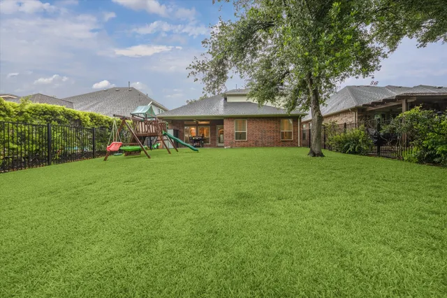 a view of a house with a big yard and a large tree