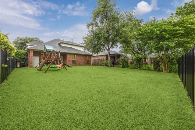 a view of a house with a big yard and large trees
