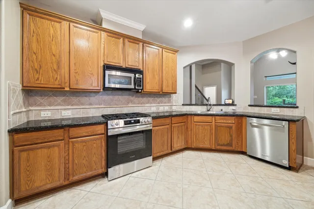 a kitchen with stainless steel appliances granite countertop a stove sink and microwave