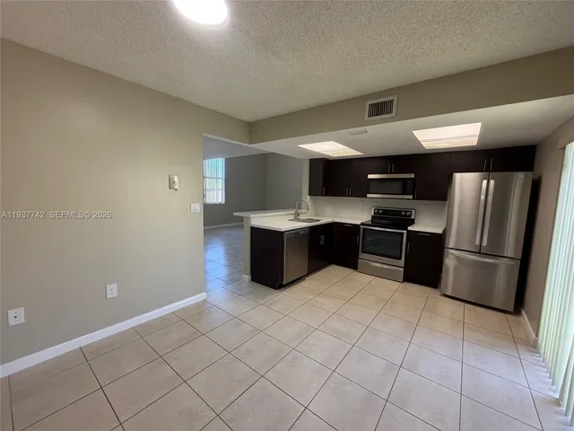 a kitchen with stainless steel appliances a refrigerator sink and cabinets