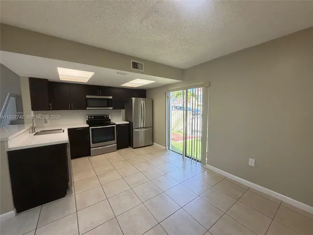 a large kitchen with a stove a sink and a refrigerator