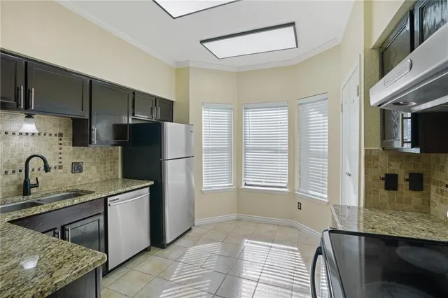a kitchen with stainless steel appliances granite countertop a sink stove and refrigerator