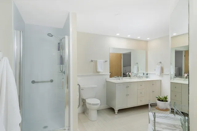 a bathroom with a double vanity sink toilet mirror and bathtub