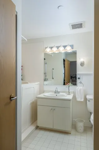 a bathroom with a double vanity sink mirror and toilet