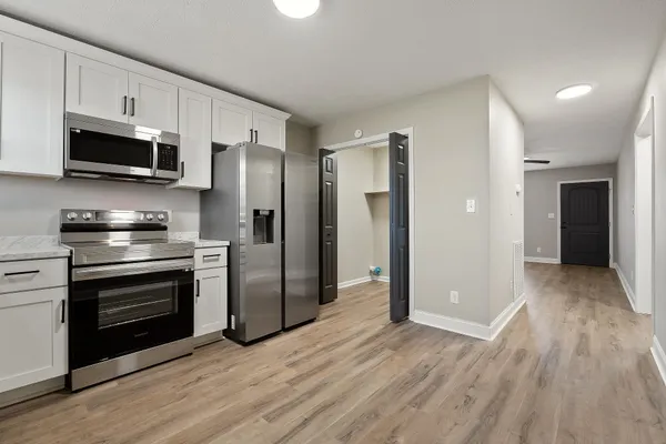 a kitchen with stainless steel appliances granite countertop a refrigerator and a stove top oven