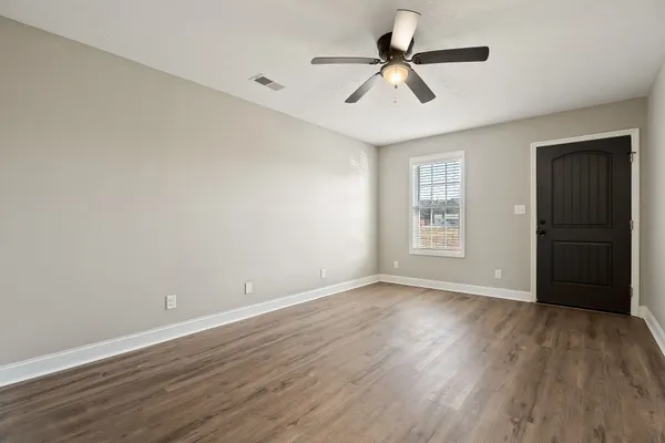 a view of room with hardwood floor and a ceiling fan