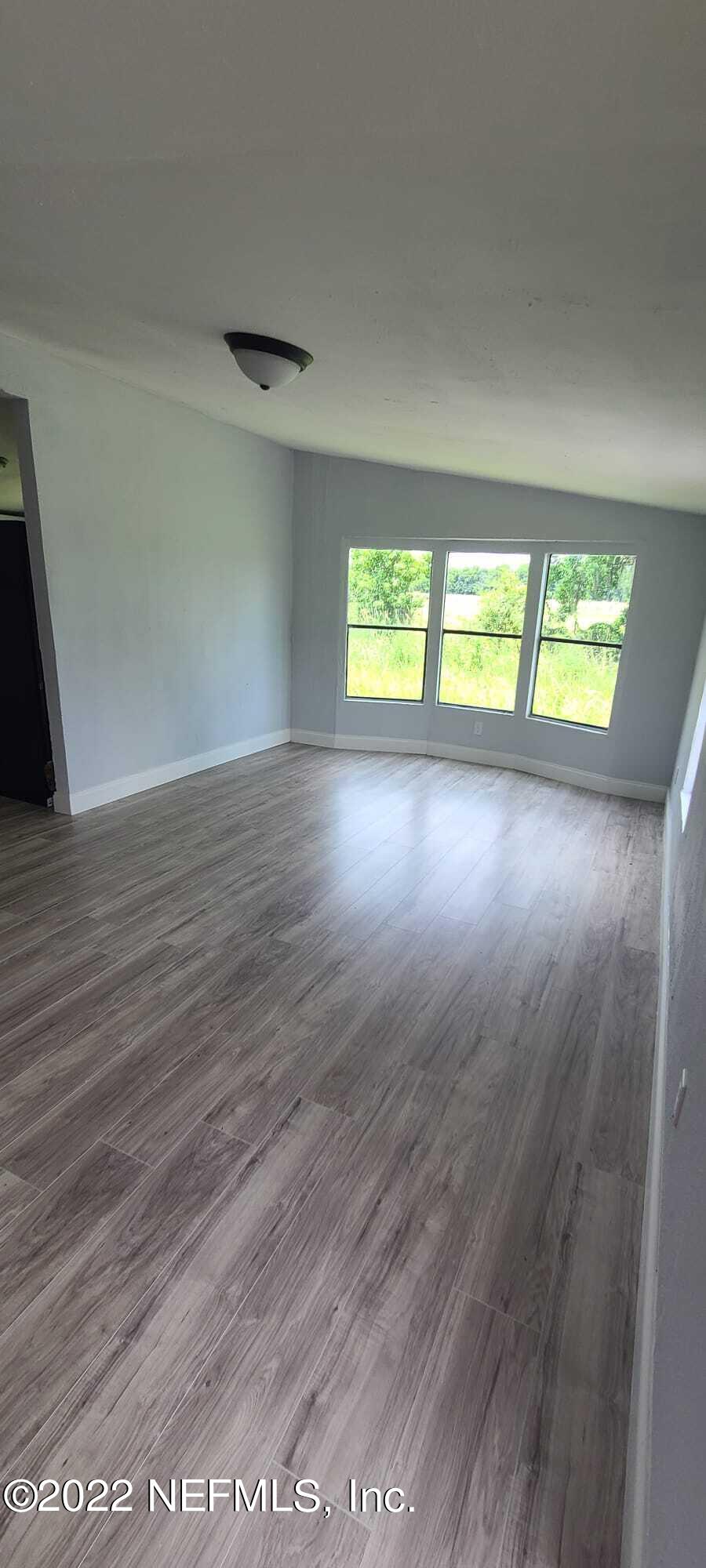 9645 Luther Beck Road Hastings, FL 32145 - Photo 8 of 17 an empty room with wooden floor and windows