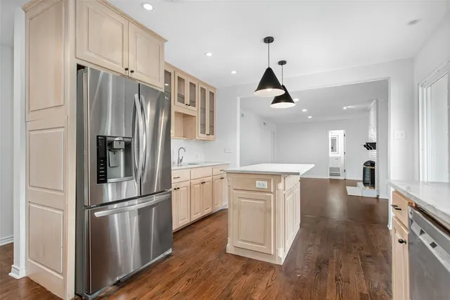 a kitchen with white cabinets stainless steel appliances and wooden floor