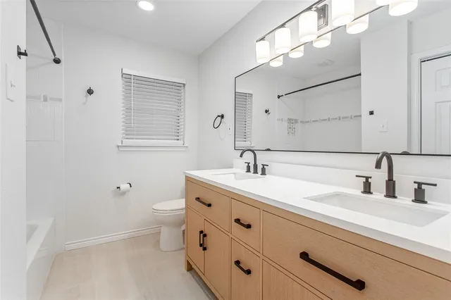 a bathroom with a double vanity sink toilet and a mirror