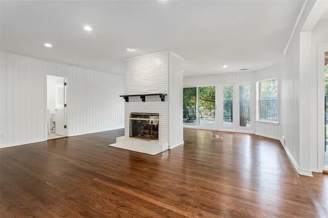 a view of empty room with wooden floor and fireplace