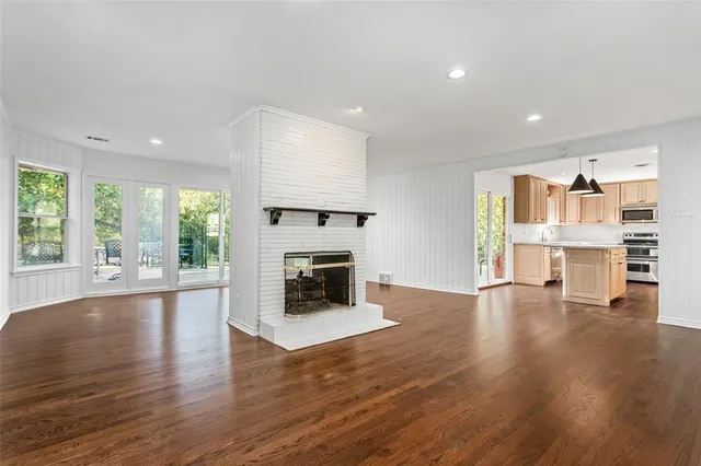 a view of empty room with wooden floor and fireplace