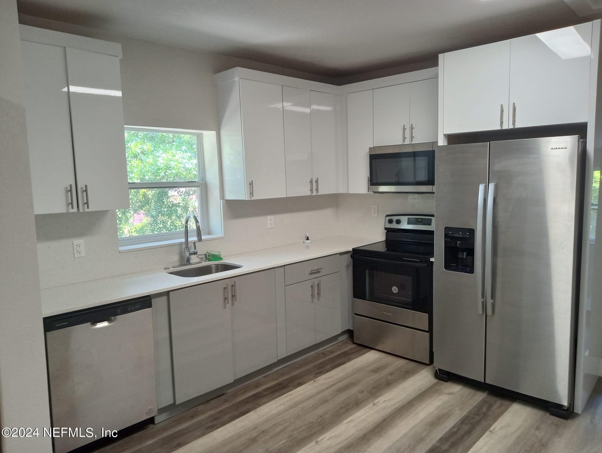 a kitchen with stainless steel appliances a refrigerator sink and microwave