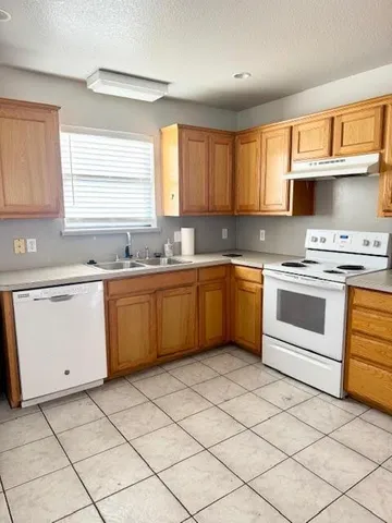 a kitchen with a stove sink and cabinets