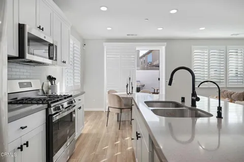 a kitchen with stainless steel appliances granite countertop a sink a stove and a refrigerator