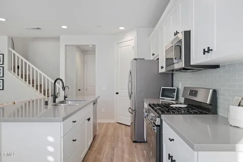 a kitchen with stainless steel appliances granite countertop a sink stove and refrigerator