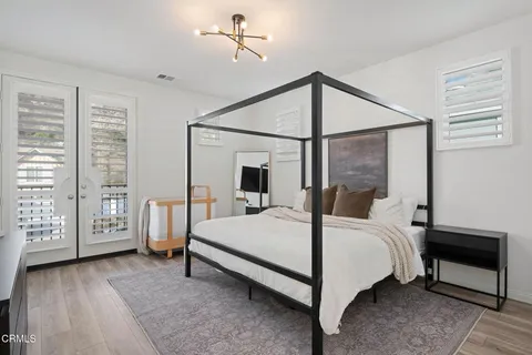 a bedroom with a bed lamp and a large window