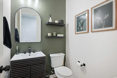 a bathroom with a toilet a sink and mirror
