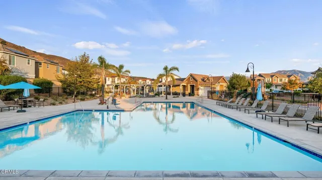 a view of swimming pool with outdoor seating and lake view