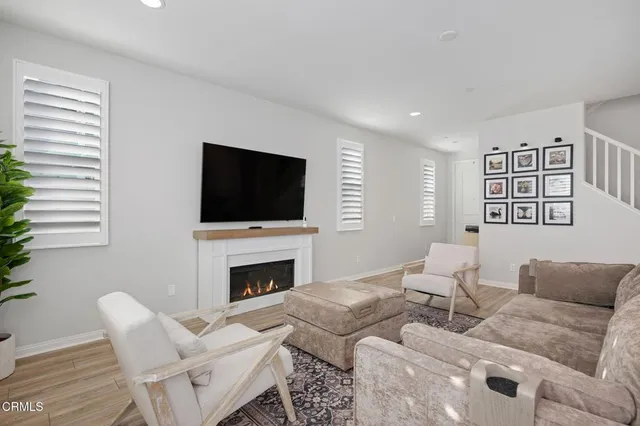 a living room with furniture a flat screen tv and a fireplace