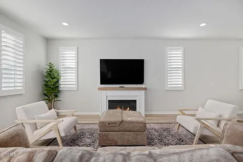 a living room with furniture a flat screen tv and a fireplace