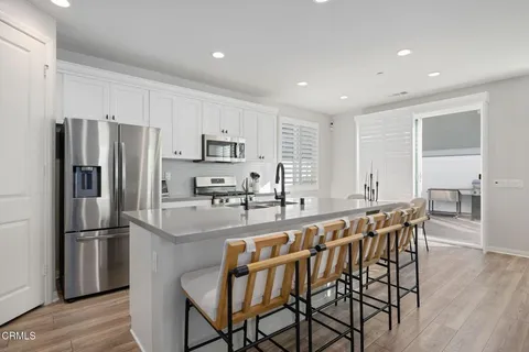 a kitchen with kitchen island a large counter top space and stainless steel appliances