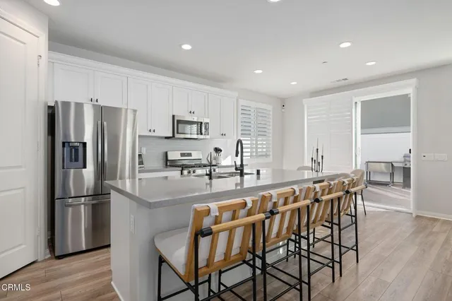 a kitchen with kitchen island a large counter top space and stainless steel appliances