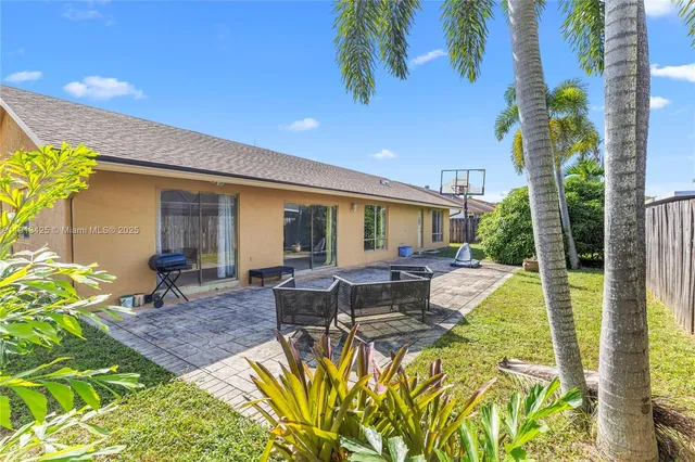 a view of a house with backyard and sitting area