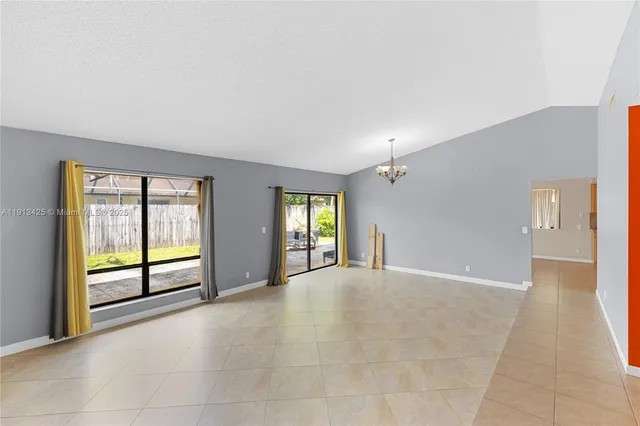 a view of an empty room with window and bathroom