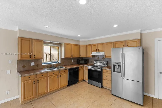 a kitchen with a sink stainless steel appliances and cabinets