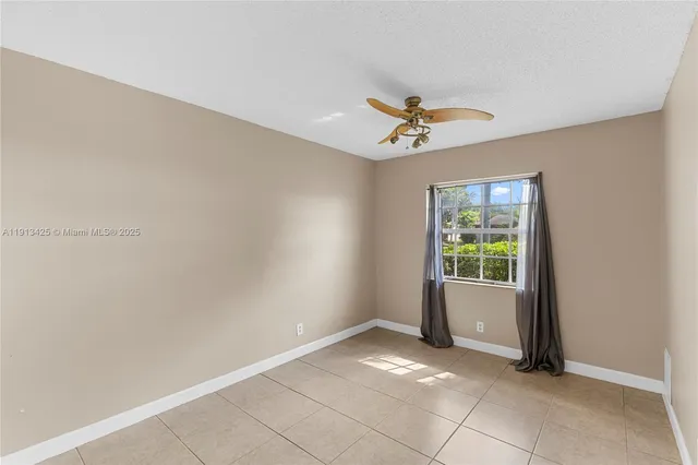 an empty room with windows and ceiling fan