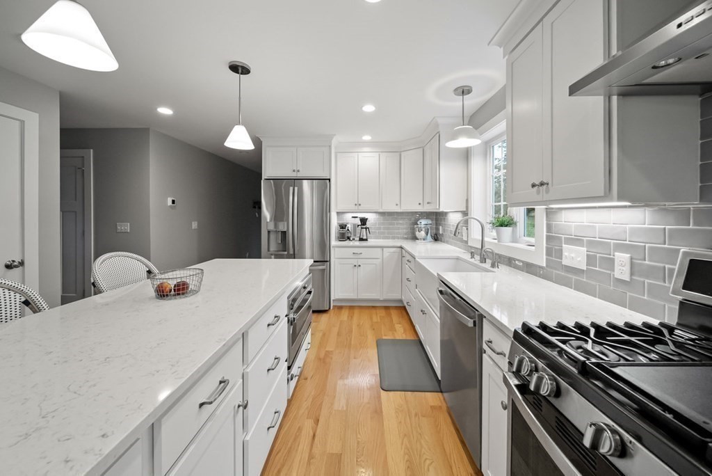 7 Kennard Road Epping, NH 03042 - Photo 8 of 42 a large kitchen with stainless steel appliances granite countertop a stove a sink and a refrigerator