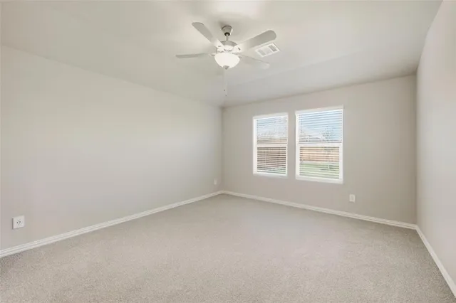 an empty room with a window and a ceiling fan